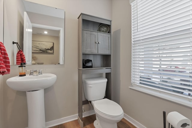 bathroom with toilet, sink, and hardwood / wood-style flooring