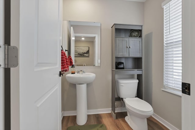 bathroom with toilet and wood-type flooring