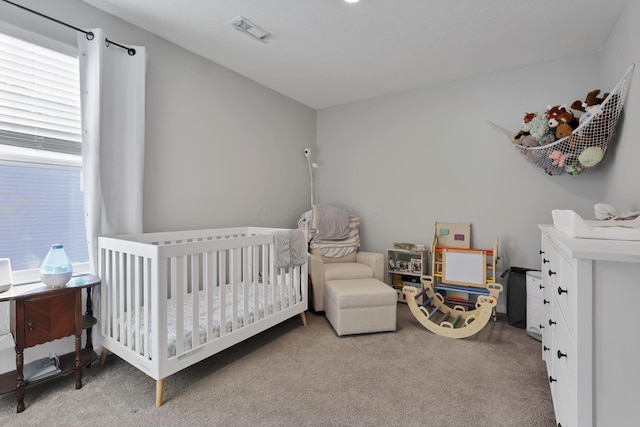 carpeted bedroom with a nursery area