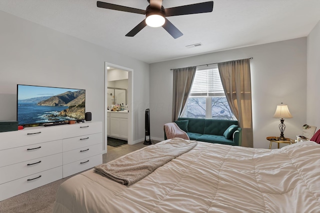 carpeted bedroom with ceiling fan and ensuite bath