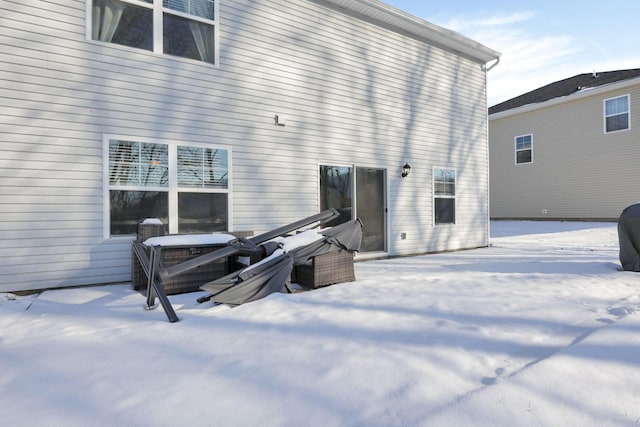 view of snow covered back of property