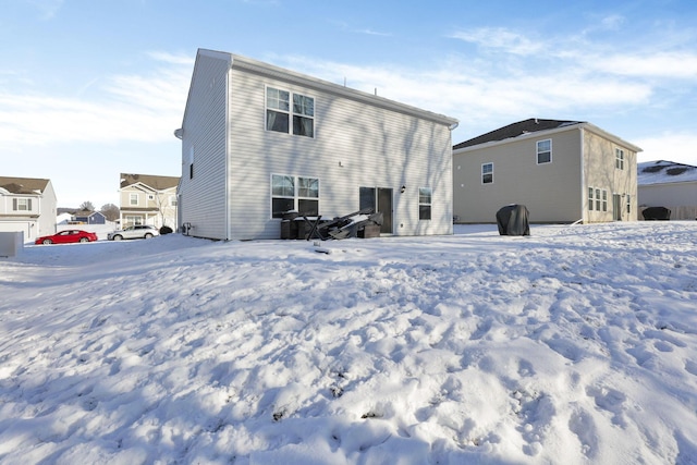 view of snow covered back of property