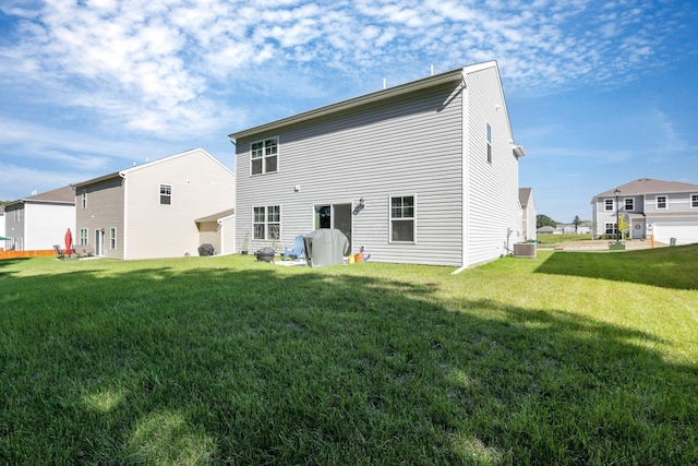 back of property featuring a lawn and central air condition unit