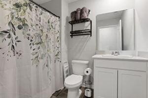 bathroom with toilet, vanity, and walk in shower