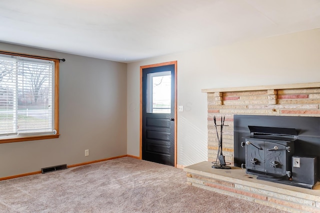 living room featuring carpet floors and a wood stove