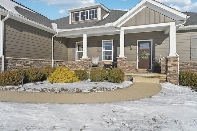 snow covered property entrance featuring a porch