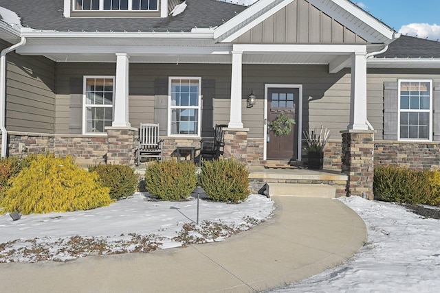 snow covered property entrance featuring covered porch