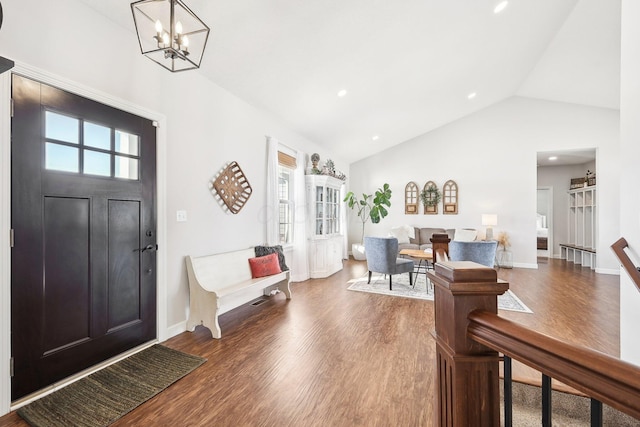 entrance foyer featuring an inviting chandelier, lofted ceiling, and hardwood / wood-style floors