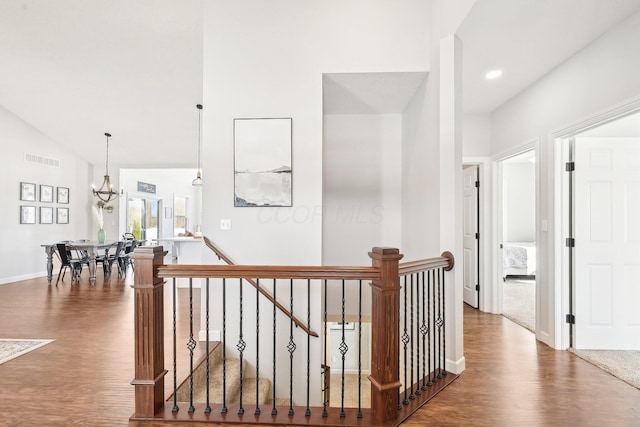 hall featuring a chandelier, vaulted ceiling, and hardwood / wood-style floors