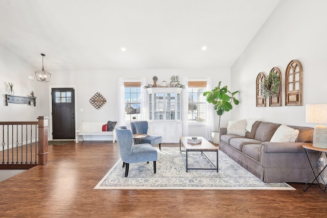 living room with lofted ceiling, a chandelier, and dark hardwood / wood-style flooring