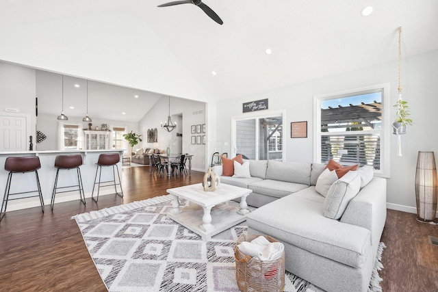 living room featuring dark wood-type flooring, plenty of natural light, high vaulted ceiling, and ceiling fan