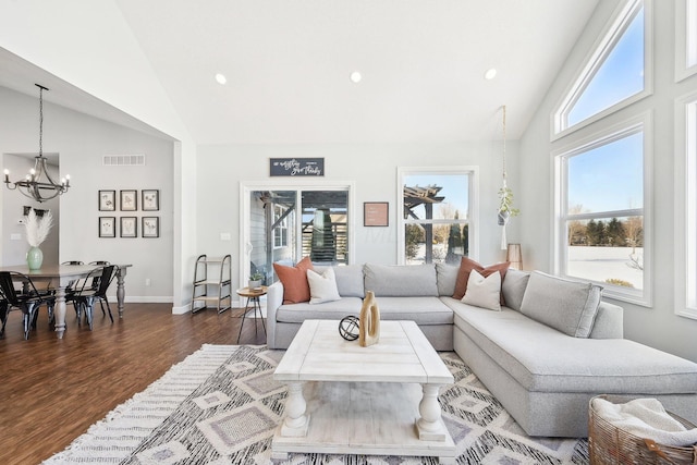 living room featuring lofted ceiling, a notable chandelier, and dark wood-type flooring