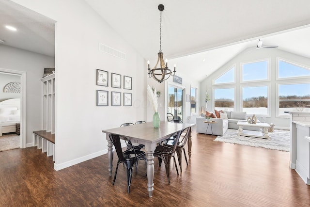 dining space featuring vaulted ceiling, an inviting chandelier, and dark hardwood / wood-style flooring