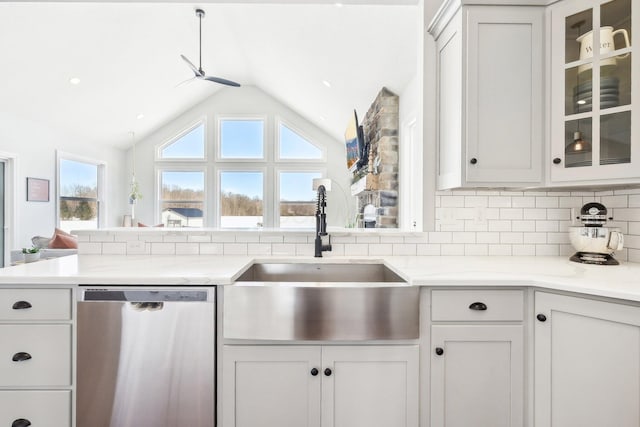 kitchen with white cabinetry, lofted ceiling, sink, decorative backsplash, and stainless steel dishwasher