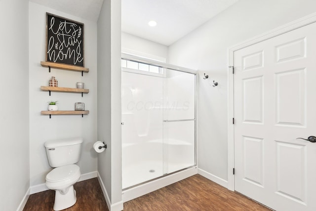 bathroom featuring walk in shower, toilet, and hardwood / wood-style floors