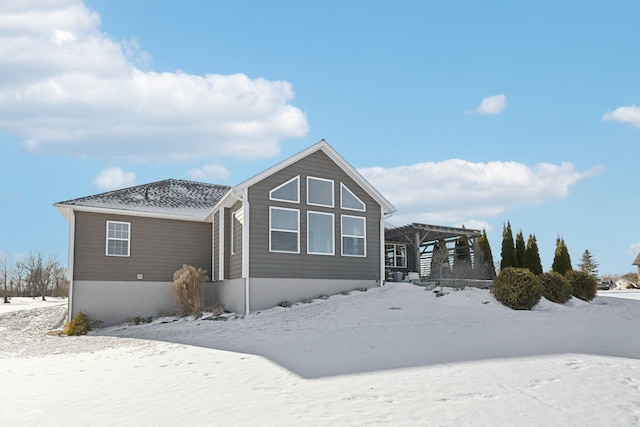 view of snowy exterior with a pergola