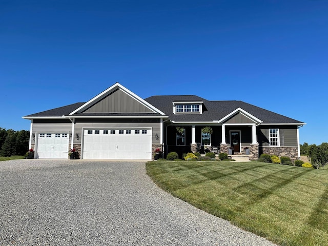 craftsman-style house with a garage, a front yard, and covered porch