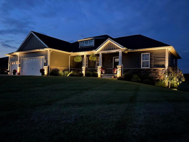 craftsman inspired home featuring a garage, covered porch, and a lawn