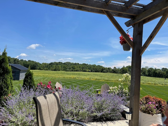 view of yard with a rural view and a pergola