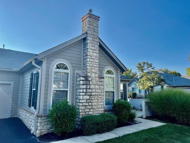 view of property exterior with a garage and a chimney