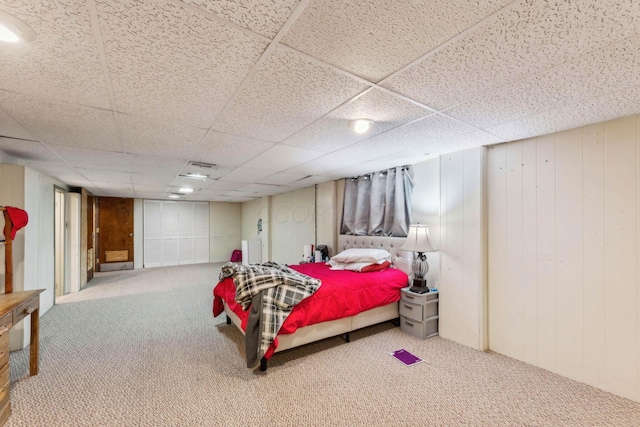 bedroom with carpet floors and wood walls