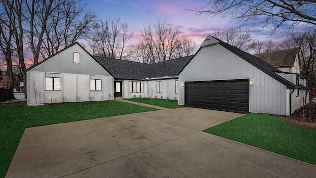 modern farmhouse with a garage and a lawn