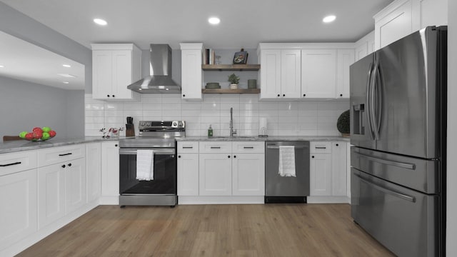 kitchen with white cabinetry, sink, wall chimney range hood, and appliances with stainless steel finishes