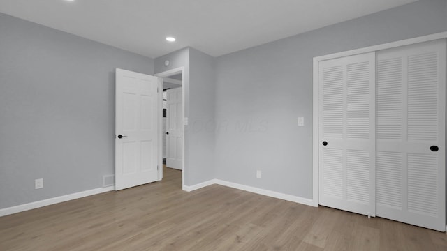 unfurnished bedroom featuring a closet and light hardwood / wood-style flooring