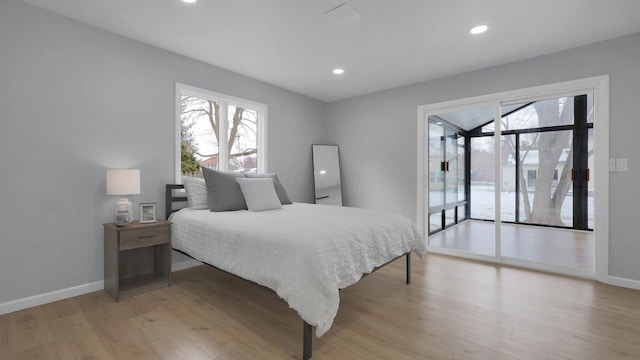 bedroom featuring access to exterior and light wood-type flooring