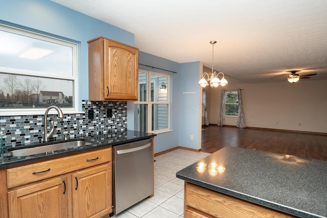 kitchen featuring light tile patterned floors, ceiling fan with notable chandelier, a sink, stainless steel dishwasher, and tasteful backsplash