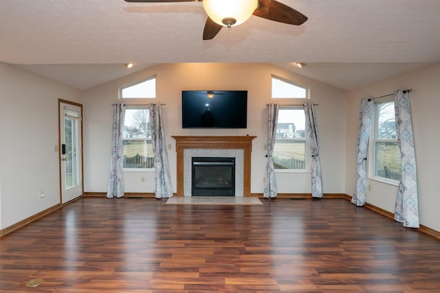 unfurnished living room with lofted ceiling, ceiling fan, a textured ceiling, a fireplace, and wood finished floors