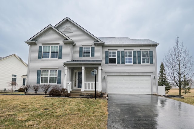 traditional home with a garage, driveway, and a front yard