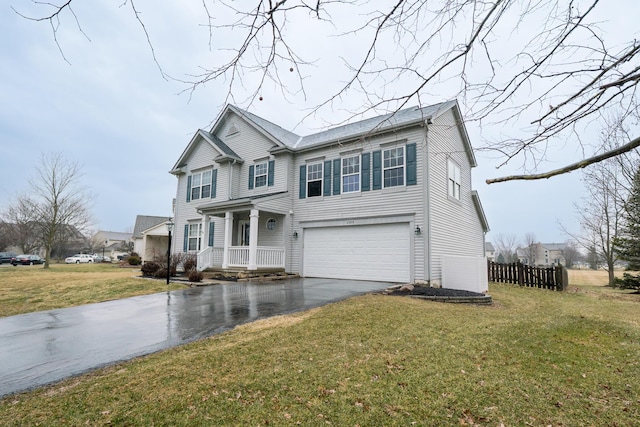 traditional-style home featuring a garage, driveway, a front yard, and fence