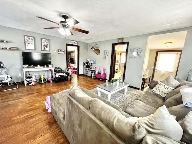 living room with ceiling fan, hardwood / wood-style floors, and a textured ceiling