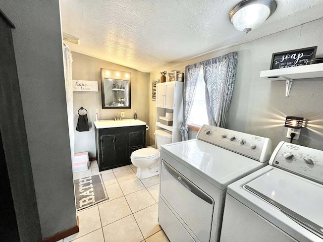 washroom featuring sink, a textured ceiling, independent washer and dryer, and light tile patterned flooring