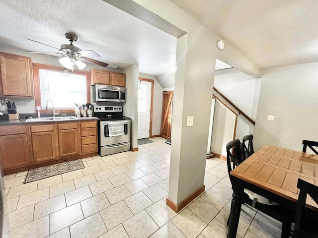 kitchen with sink, a wealth of natural light, appliances with stainless steel finishes, and light tile patterned flooring