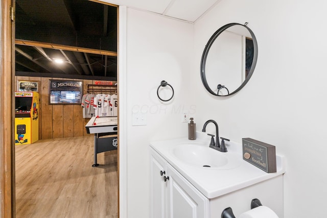 bathroom featuring vanity, hardwood / wood-style floors, and wooden walls