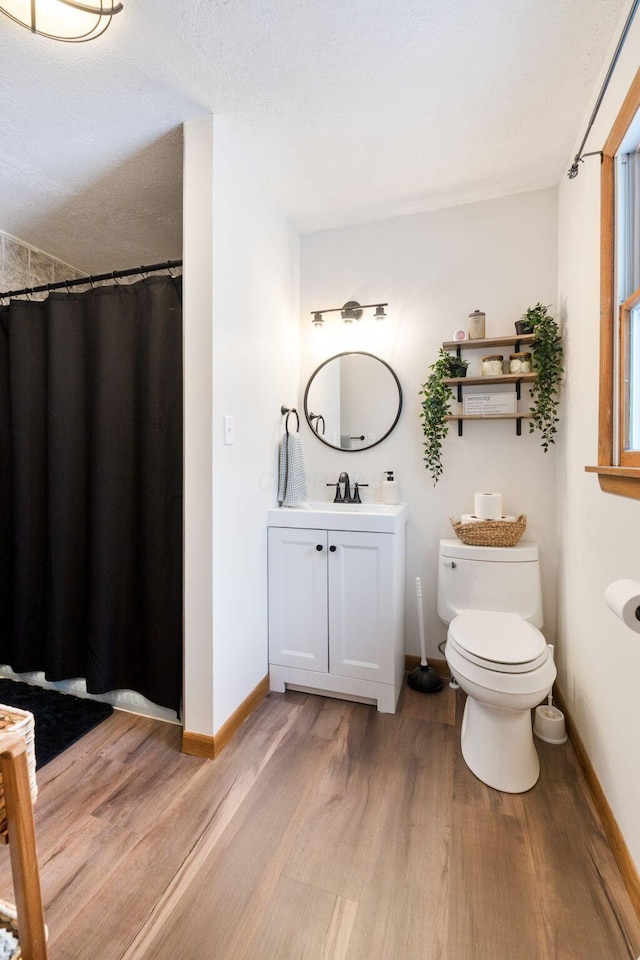 bathroom featuring hardwood / wood-style flooring, vanity, a textured ceiling, and toilet