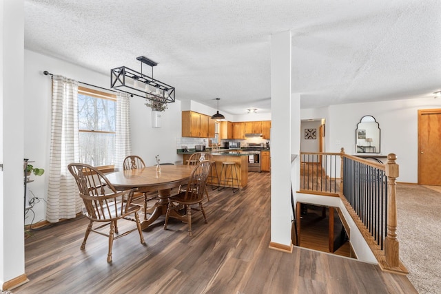 dining space featuring dark hardwood / wood-style flooring and a textured ceiling