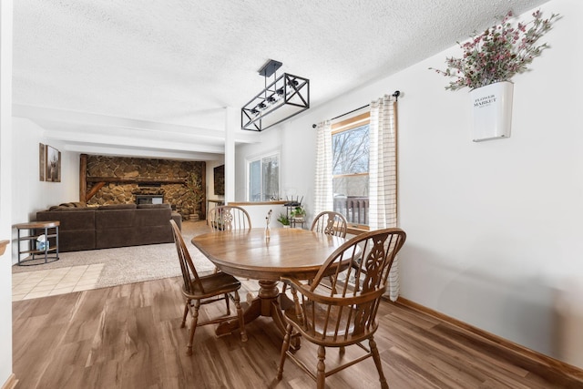 dining space featuring a textured ceiling and light wood-type flooring