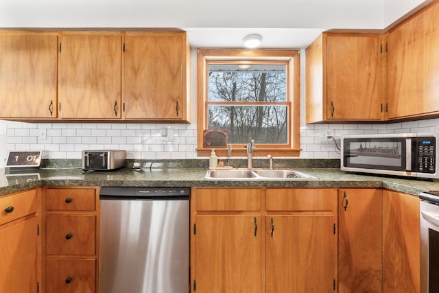 kitchen with sink, stainless steel dishwasher, and decorative backsplash