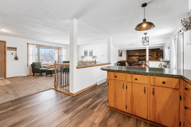 kitchen featuring pendant lighting, a textured ceiling, and dark hardwood / wood-style flooring