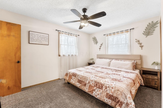 bedroom featuring multiple windows, dark carpet, and ceiling fan