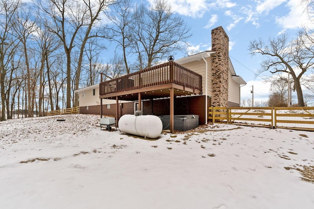 snow covered house with a wooden deck