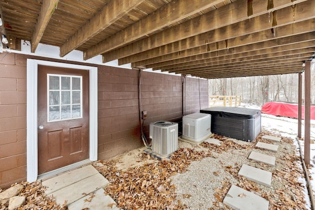 snow covered patio with cooling unit