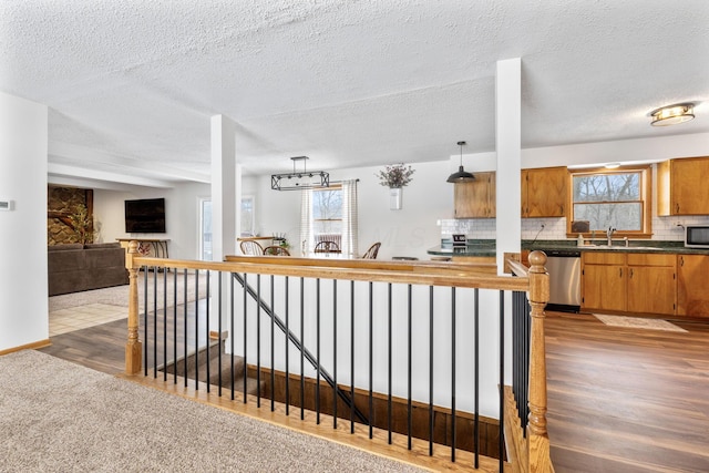 kitchen featuring stainless steel appliances, carpet, pendant lighting, and backsplash