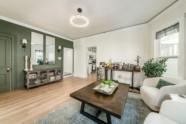 living room with a healthy amount of sunlight, wood-type flooring, and ornamental molding