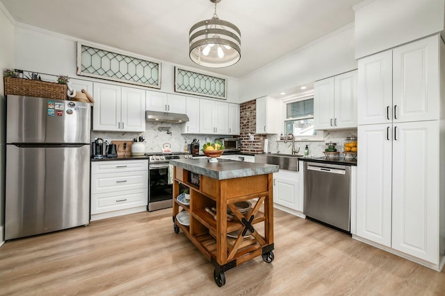 kitchen with tasteful backsplash, appliances with stainless steel finishes, sink, and white cabinets