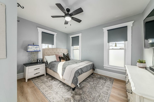 bedroom featuring multiple windows, light hardwood / wood-style floors, and ceiling fan