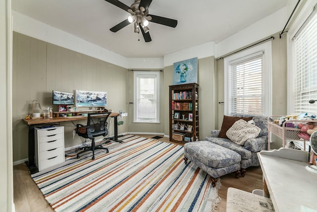 home office featuring plenty of natural light, ceiling fan, and light wood-type flooring